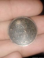 Reverse side of the coin showing denomination "ONE CENT" and date 1897 with decorative wreath.