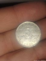 Reverse side of a 1924 Canadian 5 cent coin showing denomination, year, and maple leaf design.