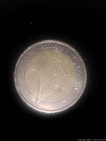 Photo of 2 Euro coin obverse side showing numeral 2 and map design.