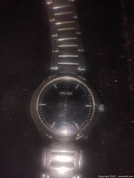 Front view showing black dial, stainless steel casing, and metal link bracelet.