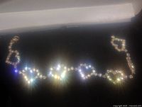 Close-up view of the vintage heart-shaped stone bracelet showing linked heart shapes and sparkling stones under light.