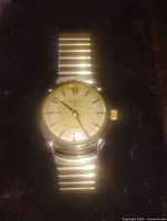 Front view of men's Elgin Shockmaster mechanical watch showing gold filled case, cream dial with gold hour markers, and expandable gold-tone bracelet.