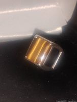 Front angled view showing the rectangular golden-brown tiger eye gemstone set in a thick silver bezel with wide band design.