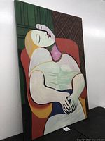 Angled view of large abstract oil painting on canvas showing seated figure with eyes closed in vibrant colors and framed edges