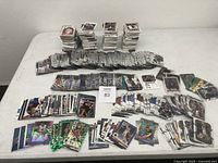 Overview of multiple stacks of basketball cards arranged on a flat surface showing the quantity and variety, including special inserts and holographic cards visible in front.