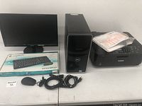 Complete computer setup with Dell tower, Canon printer, Logitech wireless keyboard and mouse in original box, power and connection cables, all arranged on a table