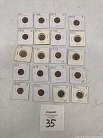Overview of all 22 Lincoln Wheat pennies in individual holders showing dates and mint marks.