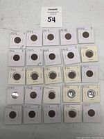 Top-down view of all 24 Lincoln Wheat Pennies in protective sleeves with mint marks and year labels visible.