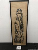 Full view of framed vintage print of a lady with crossed hands showing stylized line art in black ink on aged paper.