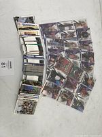 Photo showing loose stack of WWF holographic and prizm insert wrestling cards spread over a surface.