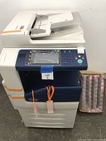Front view of the Xerox copier showing control panel, paper trays and power cord attached