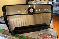 Front and partial top view of FoodSaver vacuum sealer showing control dial and buttons.