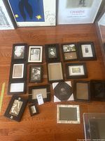 Overview of most picture frames laid out on wooden floor, showing size and style variety.