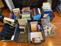 Photo showing eight baskets packed with assorted office supplies including various colors of binders, file folders, envelopes, notebooks, hanging files, and printer paper.