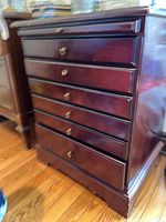 Front view of dark wooden table showing six drawers with brass handles and pull-out shelf above the top drawer.