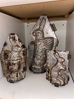 All three metal bunny molds displayed upright on shelf