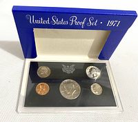 Blue display folder opened showing front side of the 1971 US proof coin set with five coins in plastic case.