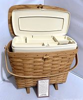 Open basket showing white plastic organizer insert with attached lid and multiple compartments. Original product paper placed in front.