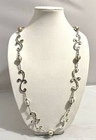 Silver tone Brighton scroll necklace displayed on a mannequin bust, showing ornate scroll design and pearl beads.
