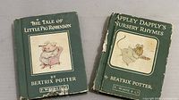 Two vintage Beatrix Potter books with significant wear, titles visible on covers