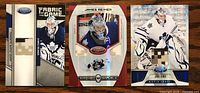 Front view of three James Reimer hockey cards each with a rectangular Canadian Forces Arid CADPAT fabric swatch embedded. Cards show Reimer in Maple Leafs uniform in different action shots.