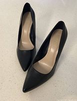 Top-down view of pair of black pointed toe dress shoes