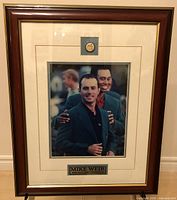 Framed photo of Mike Weir in a dark blazer with a person behind him, mounted with name plaque