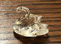 Close-up front angle of the miniature clear crystal Swarovski swan showing curved neck and faceted body.