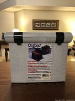 Front view of gray Oxford portable file box with black latches and handle.