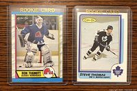 Front view of Ron Tugnutt and Steve Thomas OPC rookie hockey cards, showing player images and Rookie Card labels.