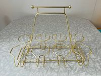 Top-down angle view of the gold-tone metal beverage caddy showing eight glass holders and a raised handle.