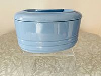 Front and side view of powder blue ceramic refrigerator dish, showing glossy finish and horizontal ridges.