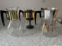 Set of three vintage coffee carafes with varying height and style, showing front view.