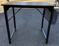 Front view showing desk top surface and metal legs, and side fabric storage panel.