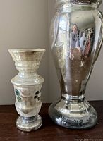 Photo of smaller 4-inch vase with worn floral paint and larger 7-inch reflective mercury glass vase