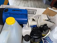 Photo showing assorted cleaning products, flashlight, charger and box with extension cord
