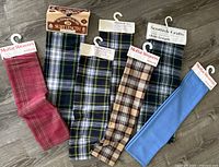 Six one-yard wool fabrics with Scottish patterns and brands visible on tags.