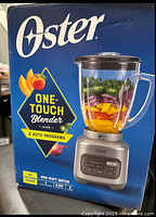 Box front image shows Oster One-Touch Blender branding, 2 auto programs, 600-watt motor, 8-cup glass jar.