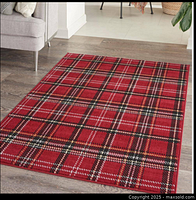 Image of the red geometric plaid area rug laid out on hardwood floor showcasing the full rug's pattern and color.
