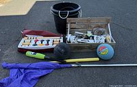 Full view of lot showing buckets, flag, bats, balls, and wooden crate with smaller items