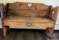 Full view of the vintage Amish solid wood bench showing heart cutouts and aged wood surface.