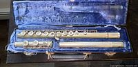 Vintage Gemeinhardt flute disassembled in original hard case with blue velvet lining. Finish shows wear.