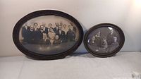Full view of two different sized, long oval antique wooden frames with bubble glass containing family portraits.