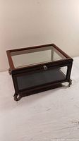 Full view of the wooden and glass display case showing the top lid and sides with glass panels.