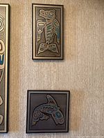 Both framed artworks hanging on textured wall