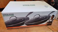 Box with Curtis Stone Everyday branding showing image of frypans and lids on front and product information on side.