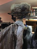 Gray fox fur pillbox hat resting on upper shelf