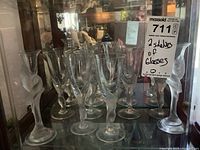 Two shelves of clear crystal stems featuring frosted dove figures: white and red wine glasses plus two larger candle holders