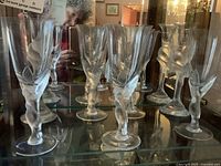 Six Snow Dove crystal wine glasses with frosted dove-shaped stems displayed on glass shelf