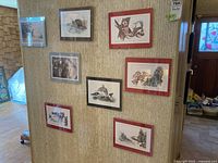 Group shot of seven 8x10 framed and matted indigenous and wildlife prints displayed on a partition